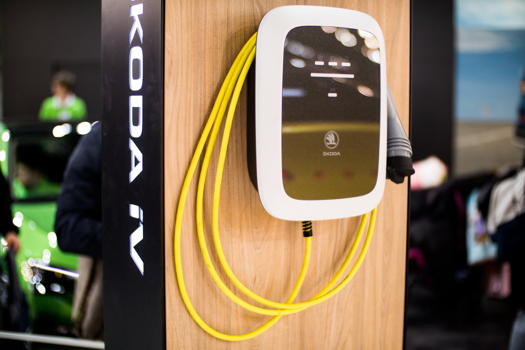 A Skoda iV home wallbox with a tethered yellow Type-2 cable