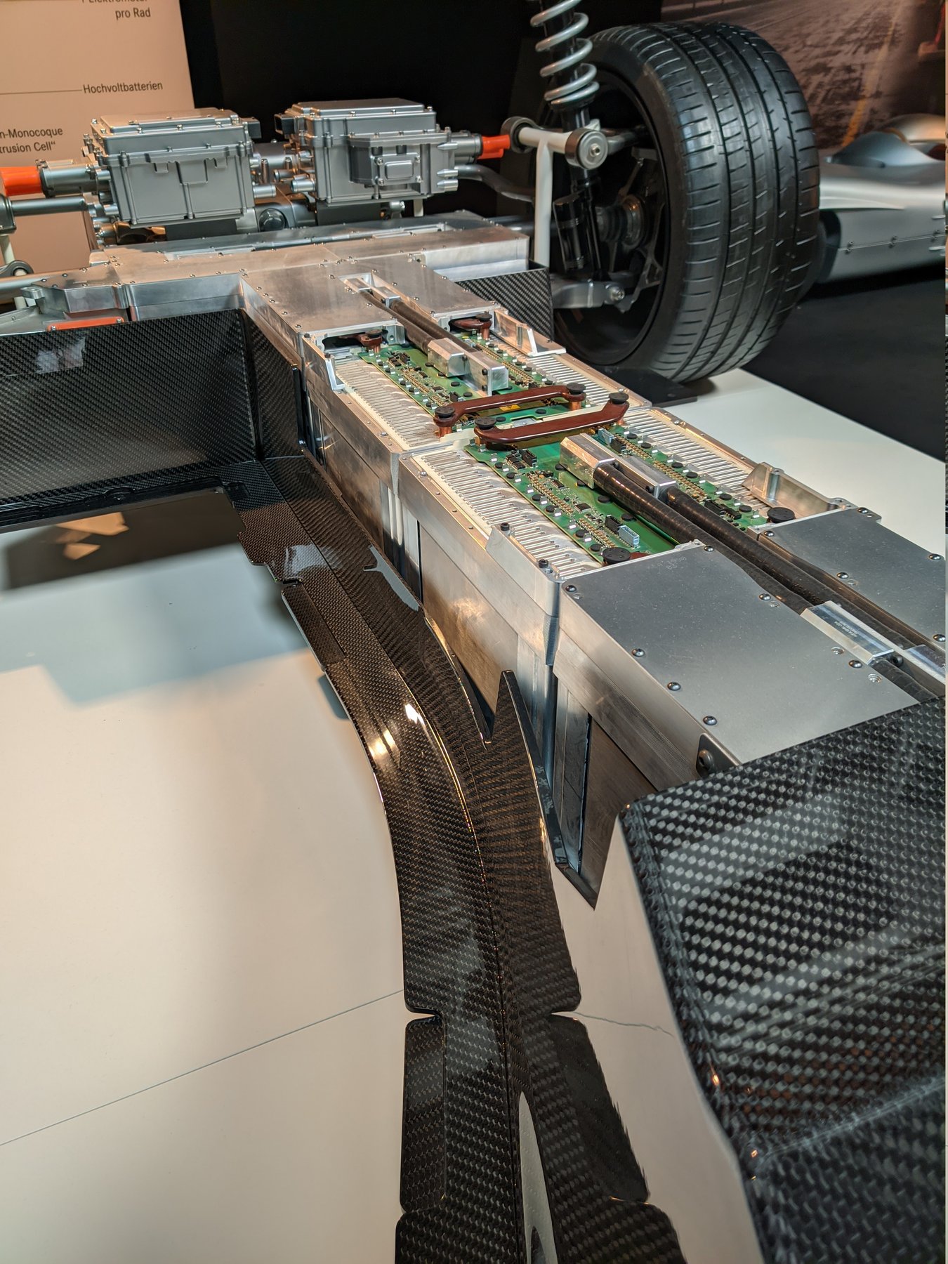 Cutaway display of an EV battery pack with a chassis, wheel and motor controllers