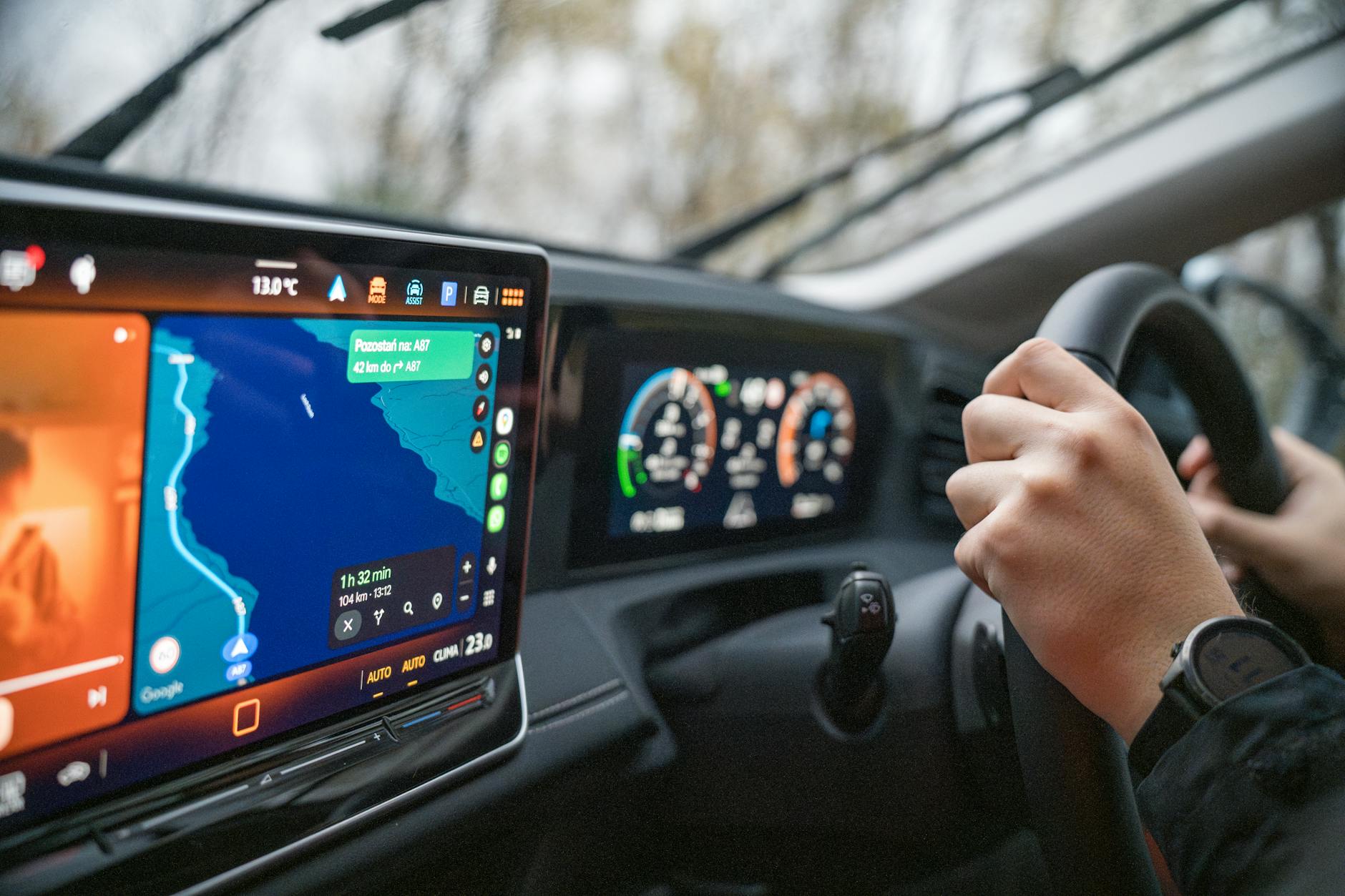 BYD electric vehicle interior showing large rotating touchscreen displaying navigation and digital instrument cluster behind steering wheel