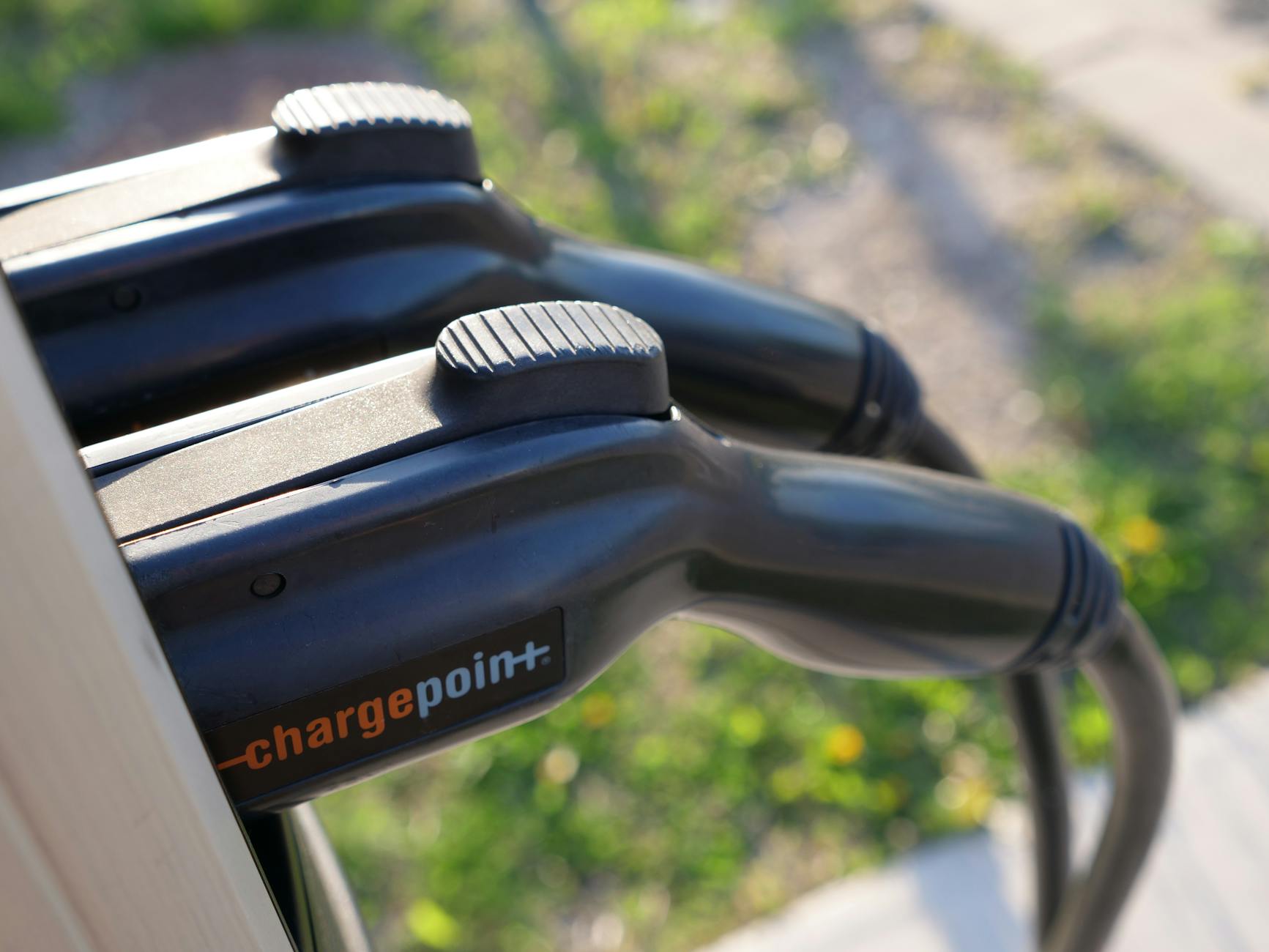 Detailed view of ChargePoint electric vehicle charging plugs at a station outdoors.