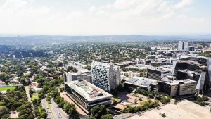 Aerial view of modern business district with office towers, contemporary buildings, and tree-lined streets