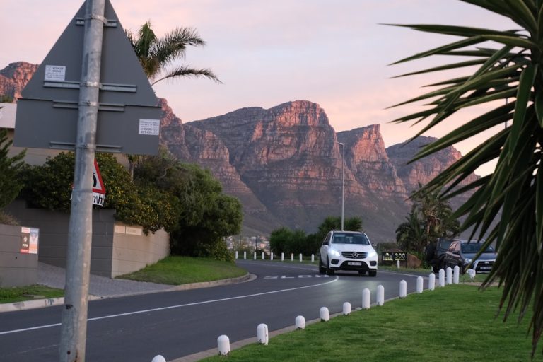 A car driving down a street with mountains in the background