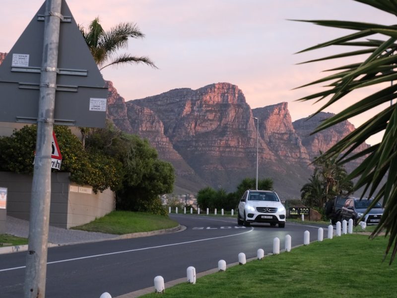 A car driving down a street with mountains in the background