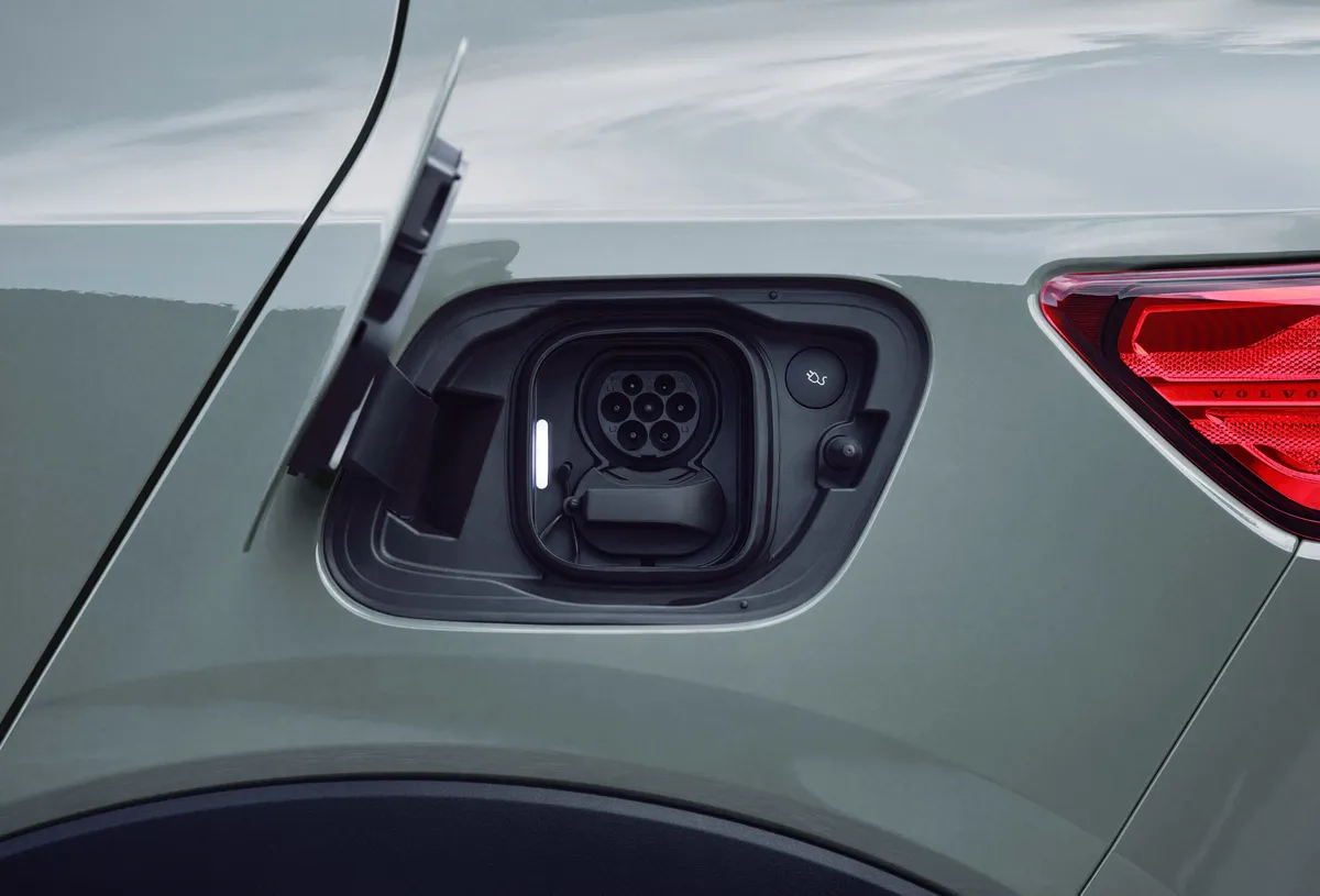 Volvo EX90 electric vehicle charging port with connector cable inserted into the driver-side rear panel