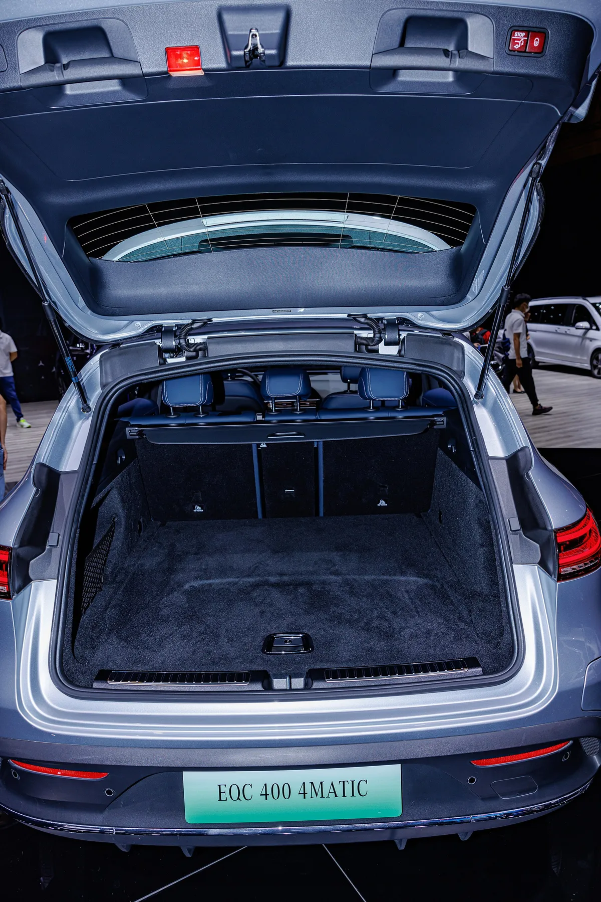 Mercedes-Benz EQC interior trunk space with open tonneau cover, showing cargo area and blue upholstery details