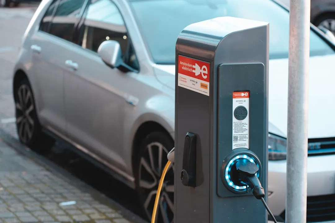 Electric vehicle charging at a public charging station in Amsterdam, Netherlands, with an EV connected to a modern charger