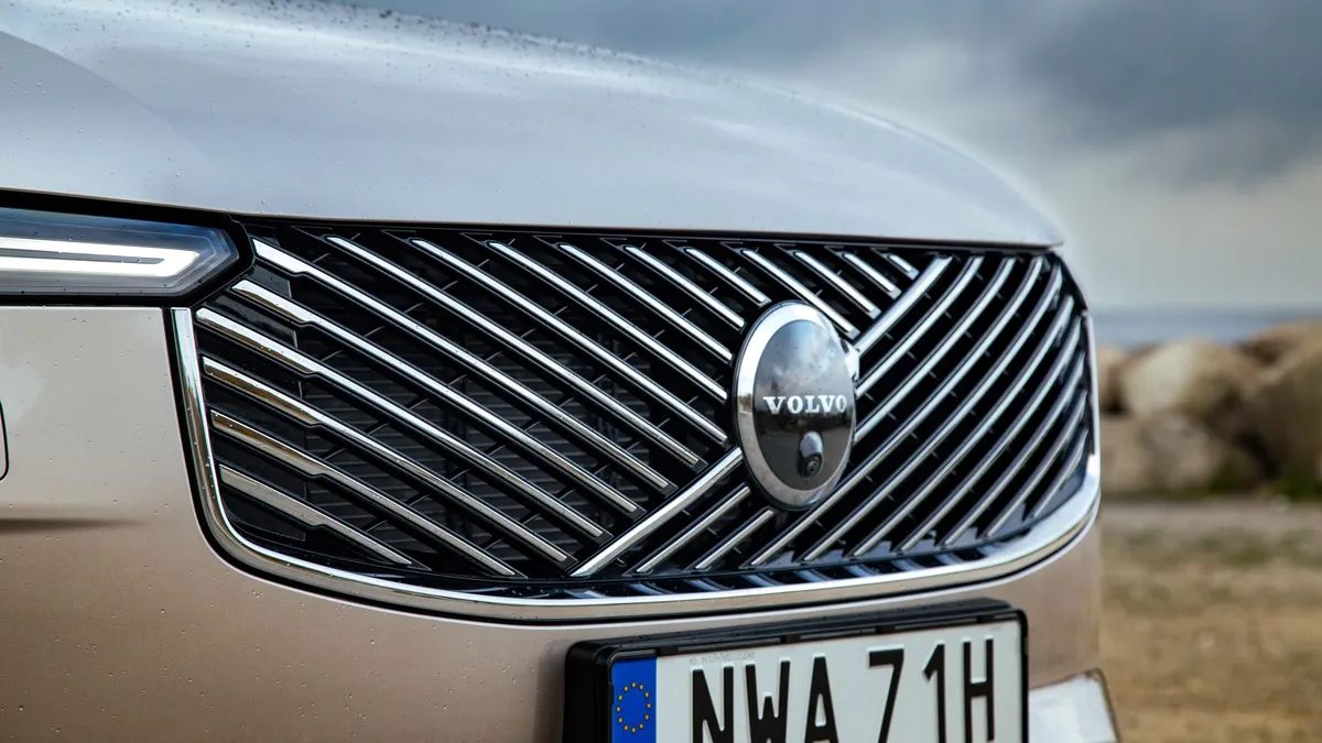 Volvo front grille with diagonal slat design and circular badge, silver SUV with LED headlights