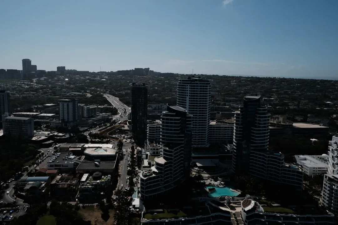 Aerial view of modern high-rise apartment buildings and residential complexes with curved architecture and swimming pools